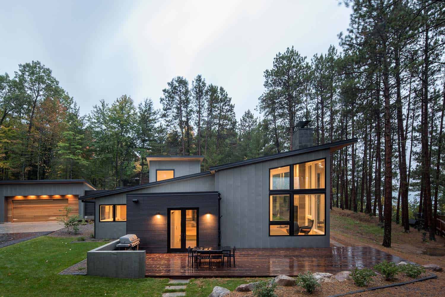 Modern lake house getaway on forested landscape in ...