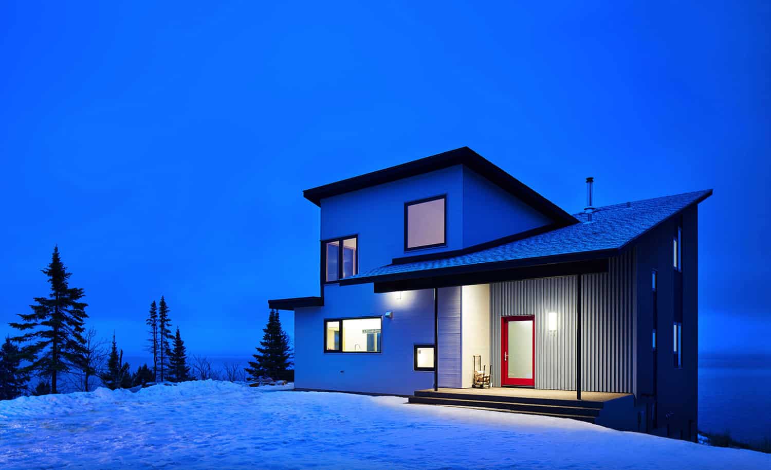 modern-lake-home-exterior-with-snow-at-dusk