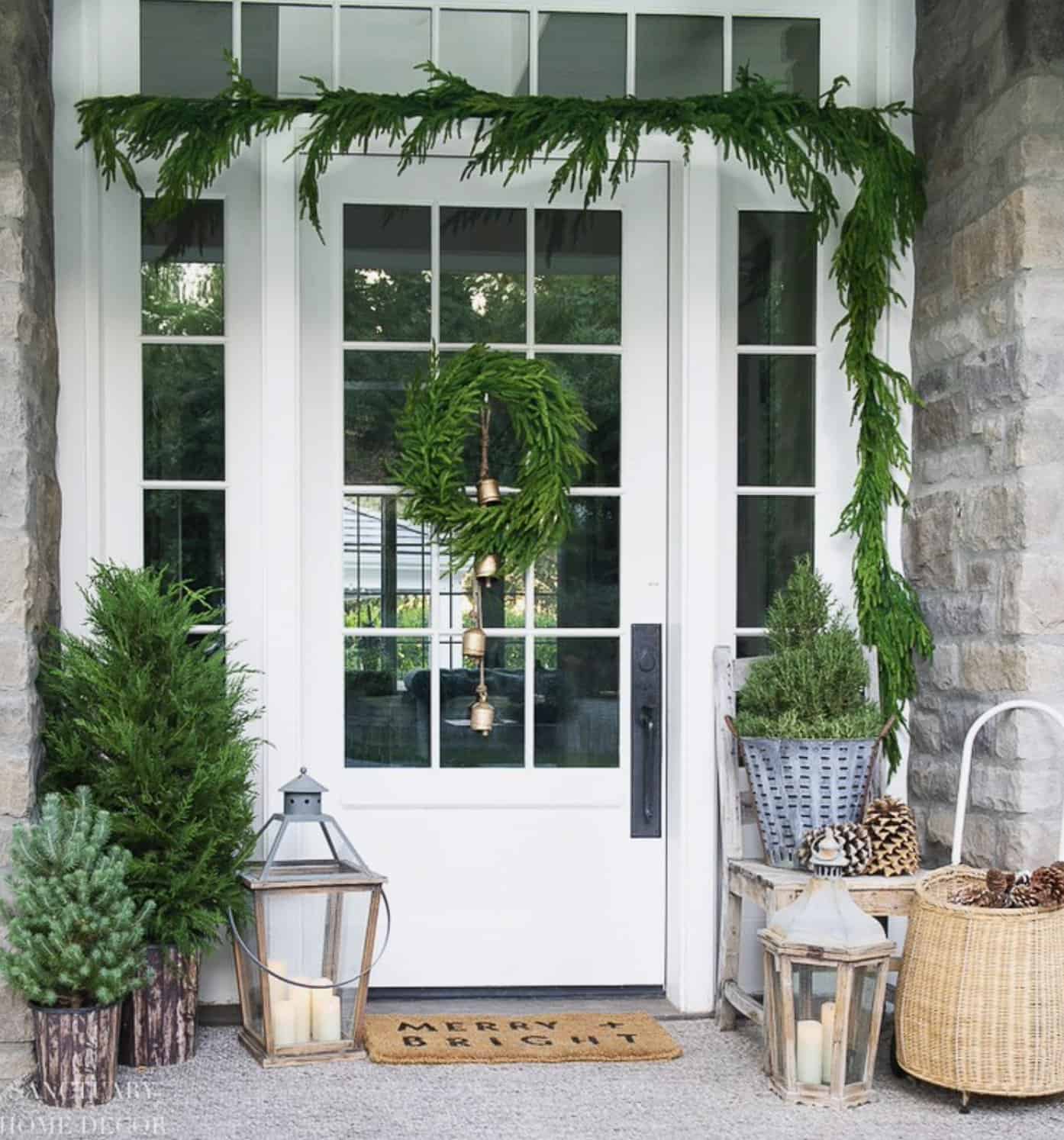 beautifully-decorated-front-porch-with-garland-a-wreath-and-trees