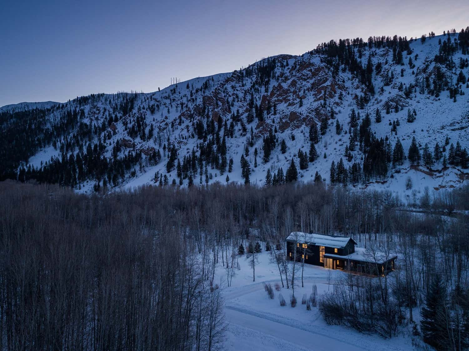 modern-barn-style-home-exterior-with-snow-sun-valley-dusk