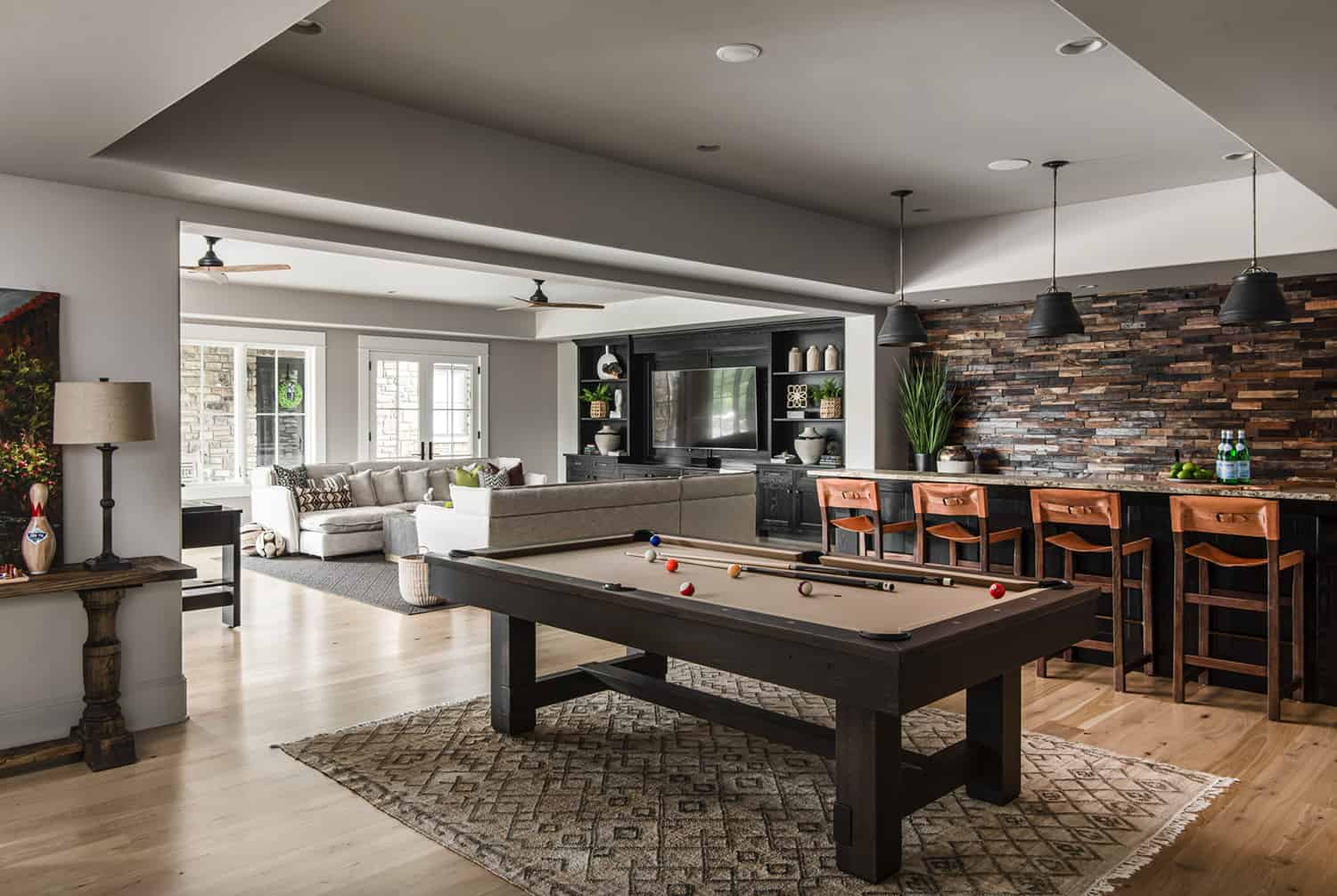 transitional-style-family-room-and-home-bar-with-a-billiard-table