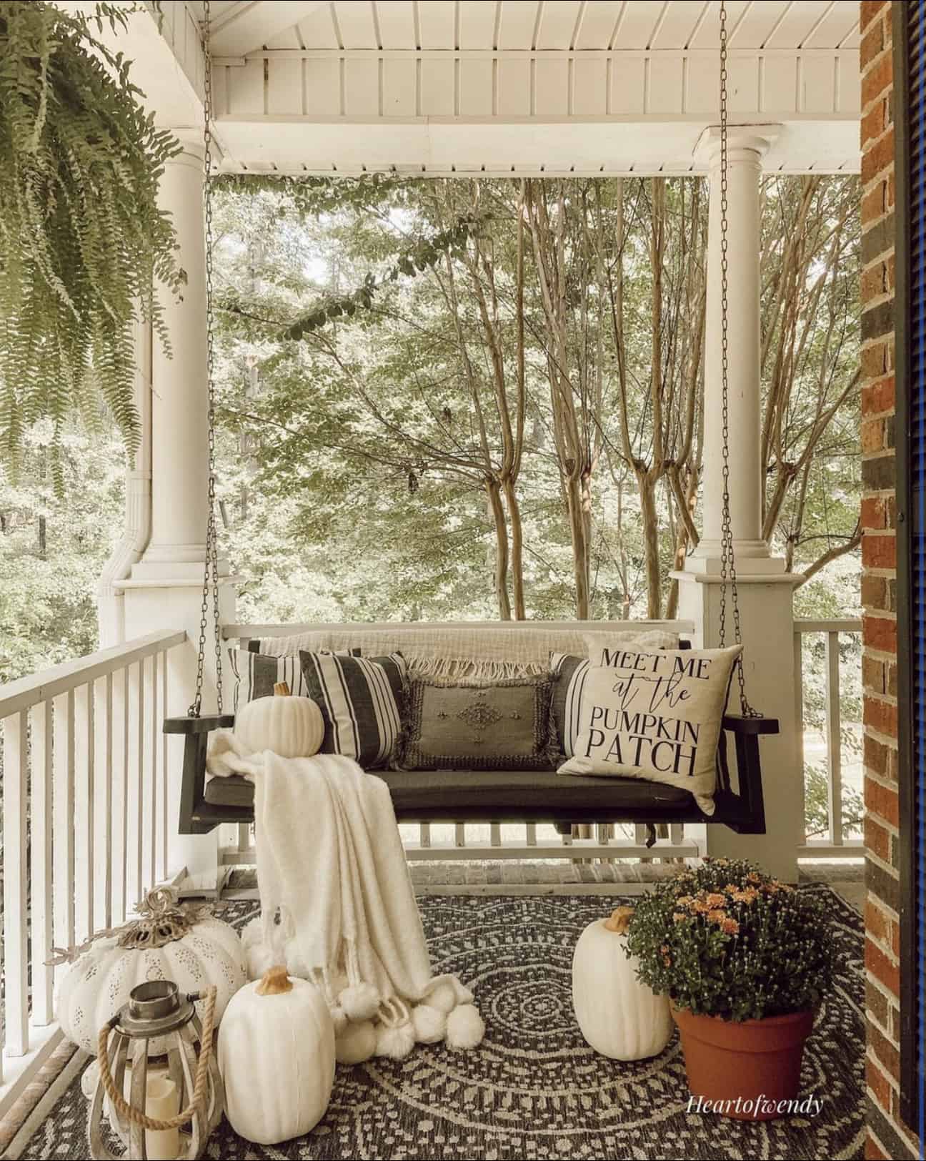 covered-outdoor-porch-with-a-swing-and-fall-decor