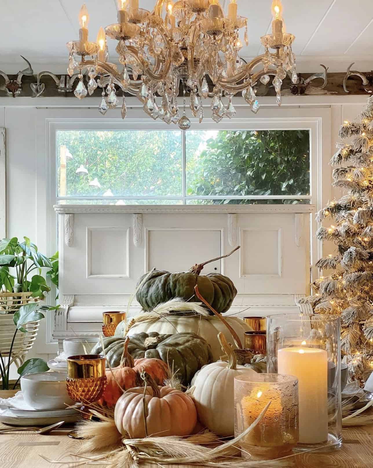 dining-table-styled-with-pumpkins-and-a-christmas-tree-in-the-background