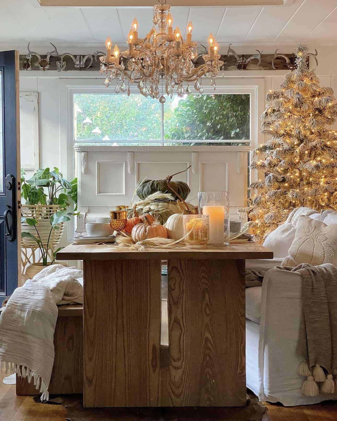 dining-table-styled-with-pumpkins-and-a-christmas-tree-in-the-background