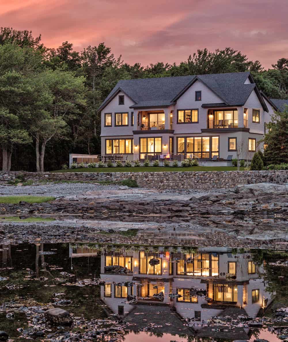 A modern shingle-style home rests peacefully on the Maine coast