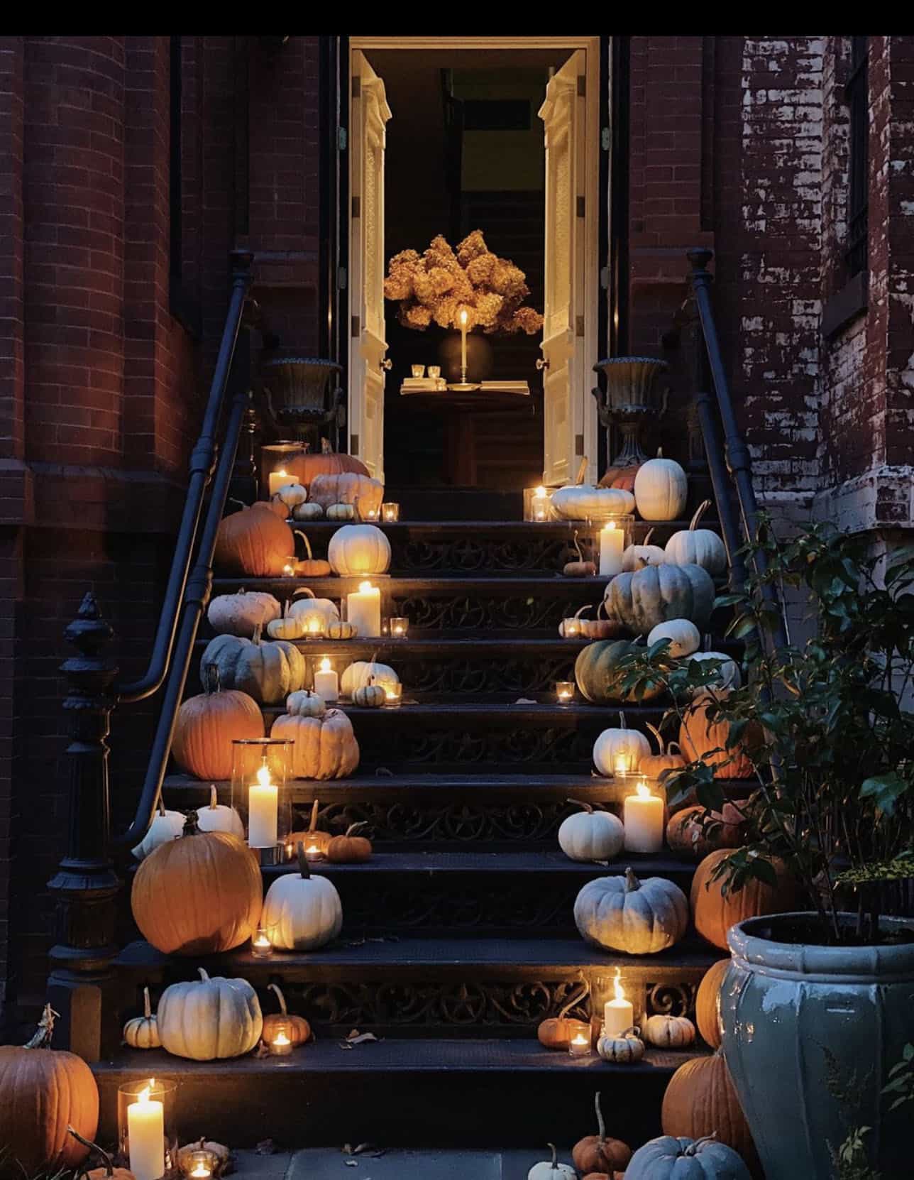 pumpkins-decorating-steps-leading-up-to-front-door-at-night-with-candles