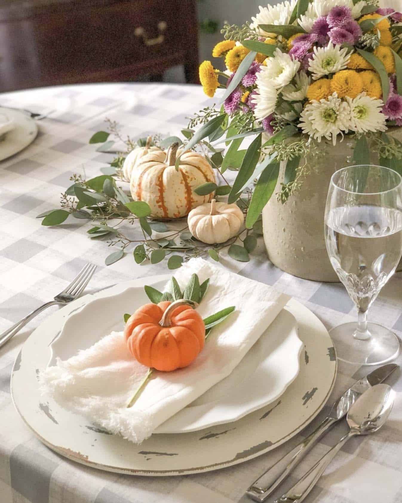thanksgiving table decorated with a mix of pumpkins and flowers