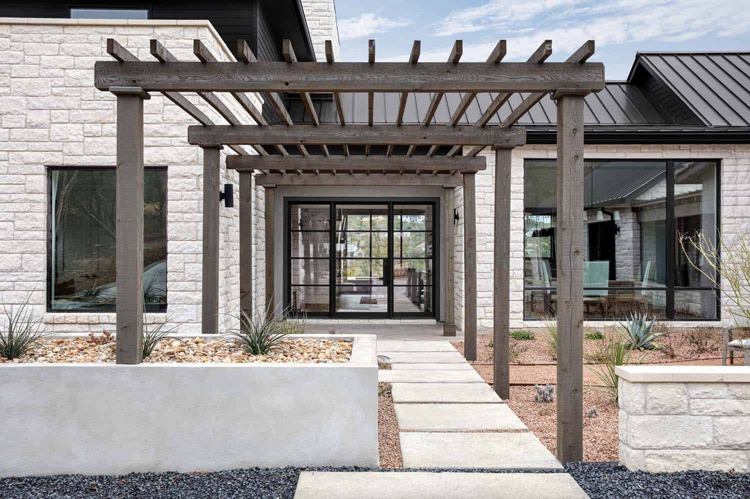 rambling-farmhouse-with-wood-pergola-entry-and-stone-pavers