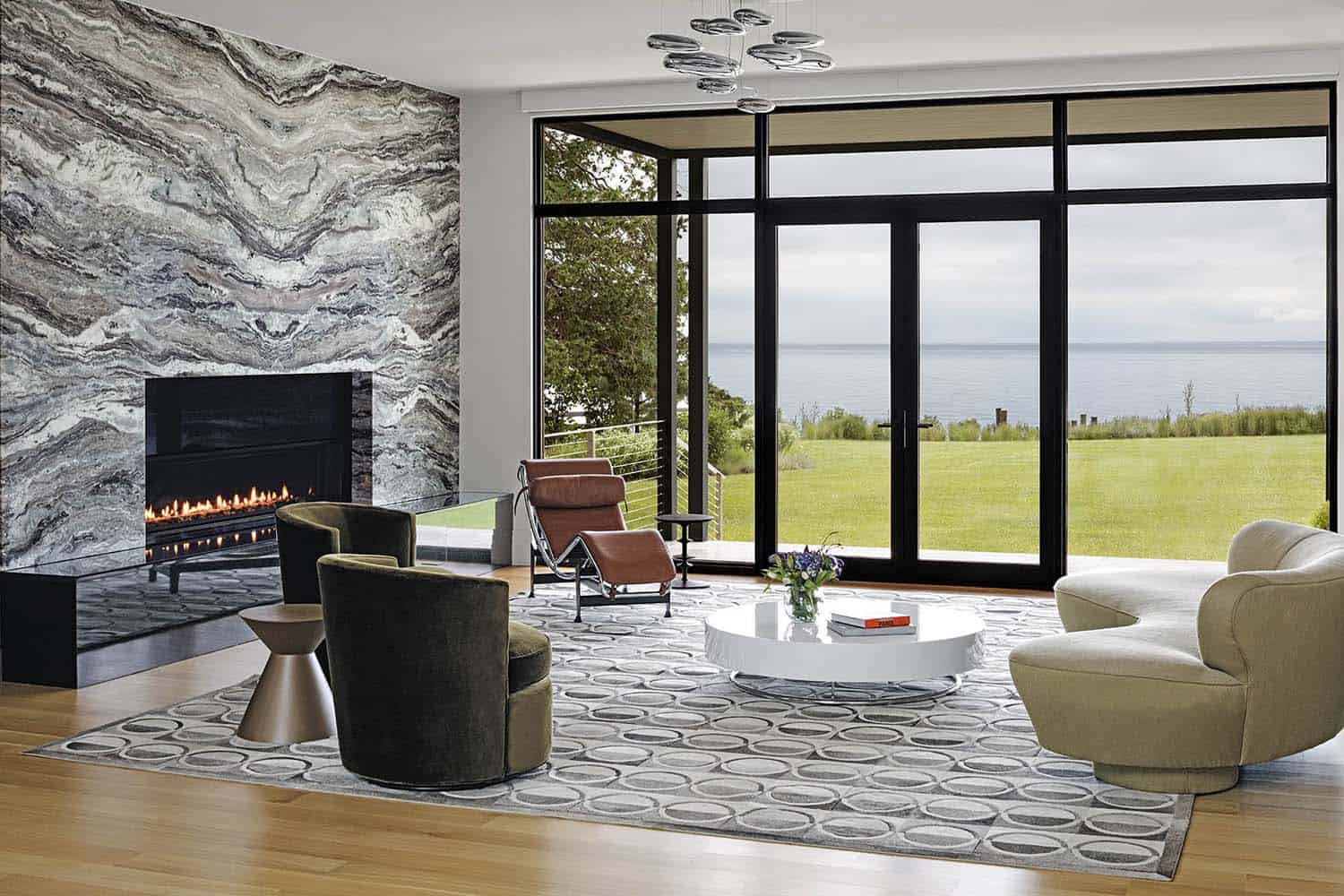 contemporary-living-room-with-marble-fireplace-wall-and-view-to-the-bay