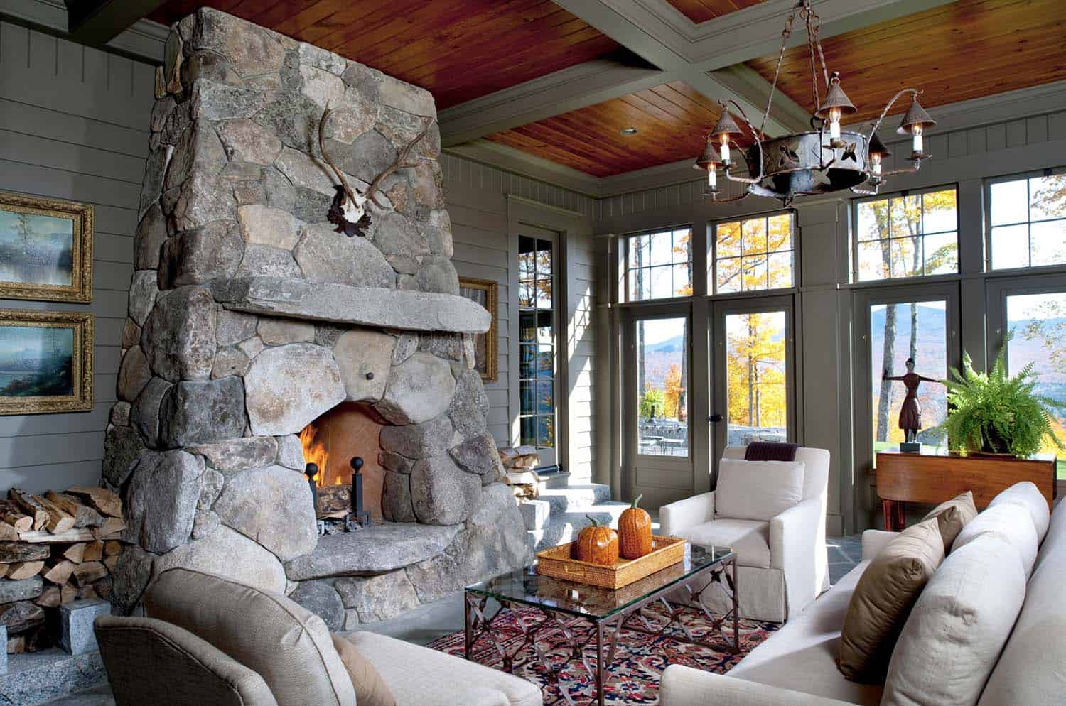 cozy-rustic-sunroom-with-a-large-rock-fireplace