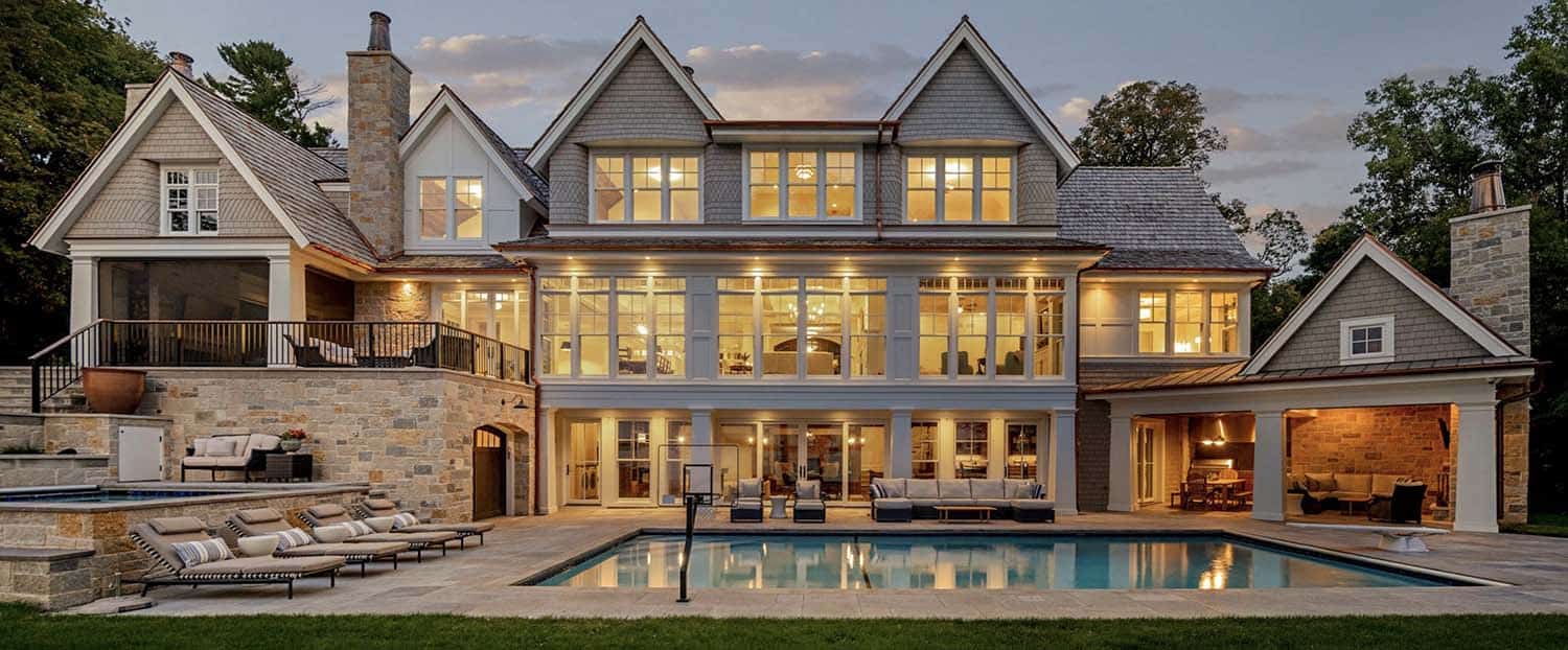 coastal-style-lake-house-exterior-with-a-pool-at-dusk