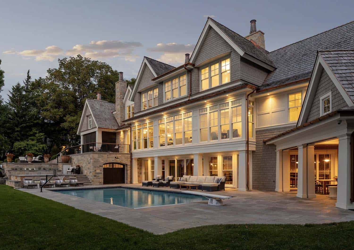 coastal-style-lake-house-exterior-with-a-pool-at-dusk