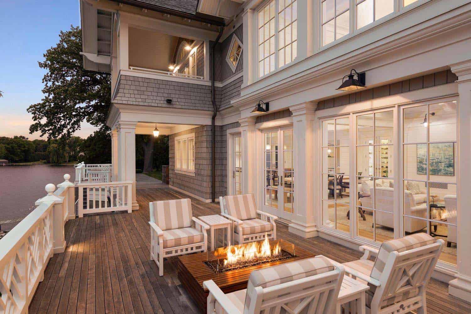 east-coast-shingle-style-lake-house-exterior-deck-with-a-fire-pit-at-dusk