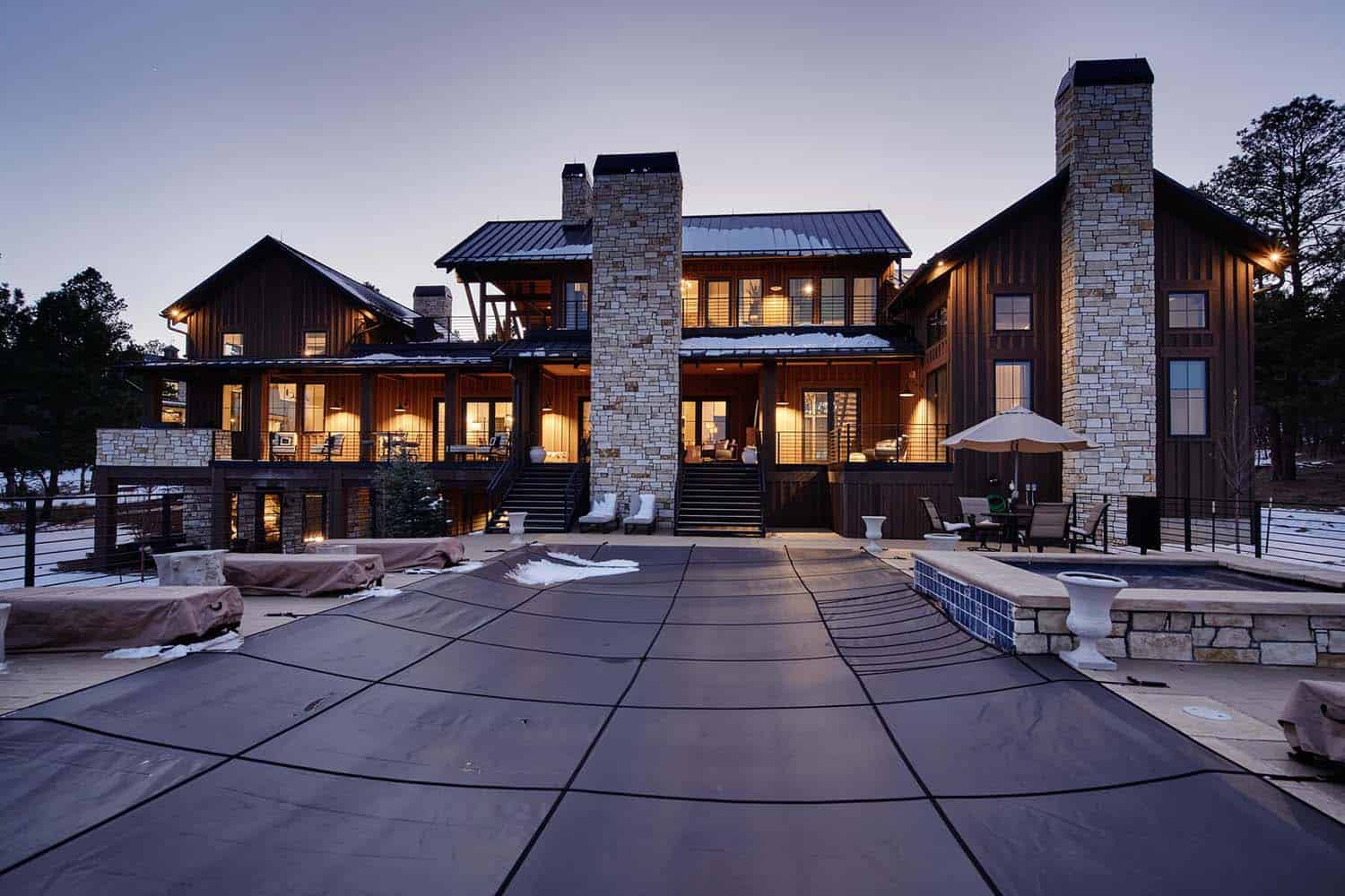 modern-glam-farmhouse-exterior-with-a-pool-at-dusk