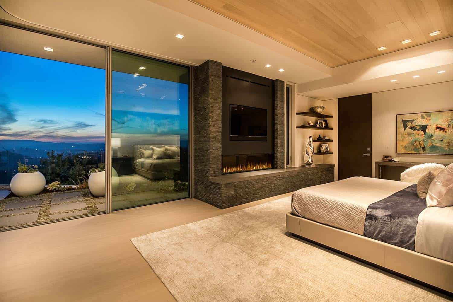 modern-bedroom-with-a-fireplace-at-dusk