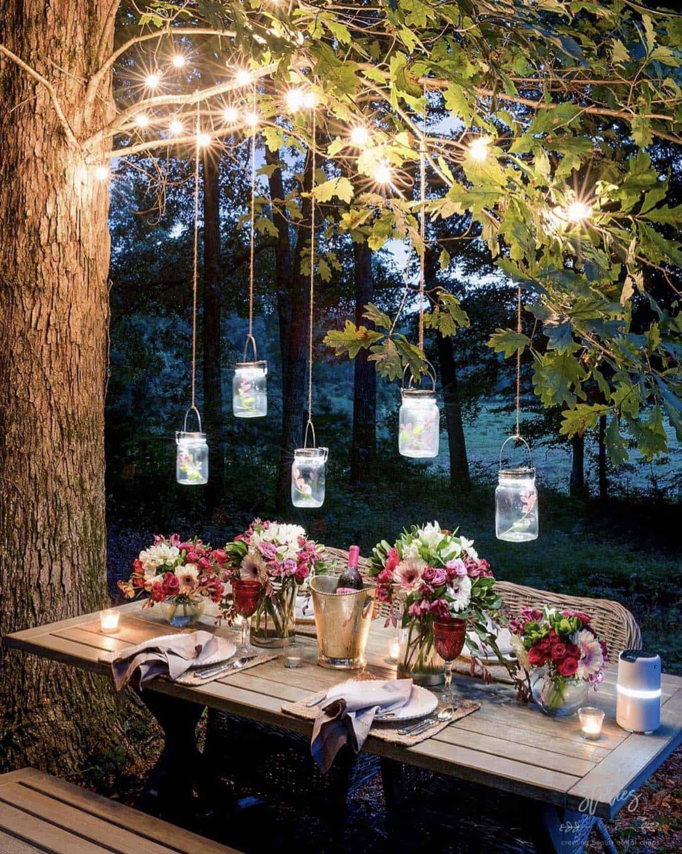 dreamy outdoor dining in a forest setting with hanging lights