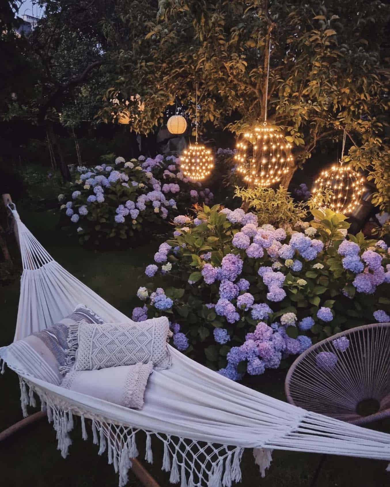 hammock in a garden with hydrangeas and hanging lights for a magical glow