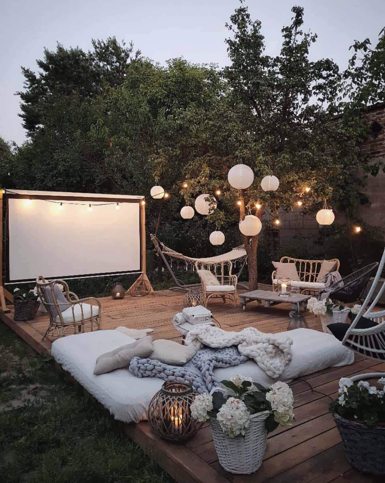 backyard terrace with string lights and a projector screen for outdoor movies