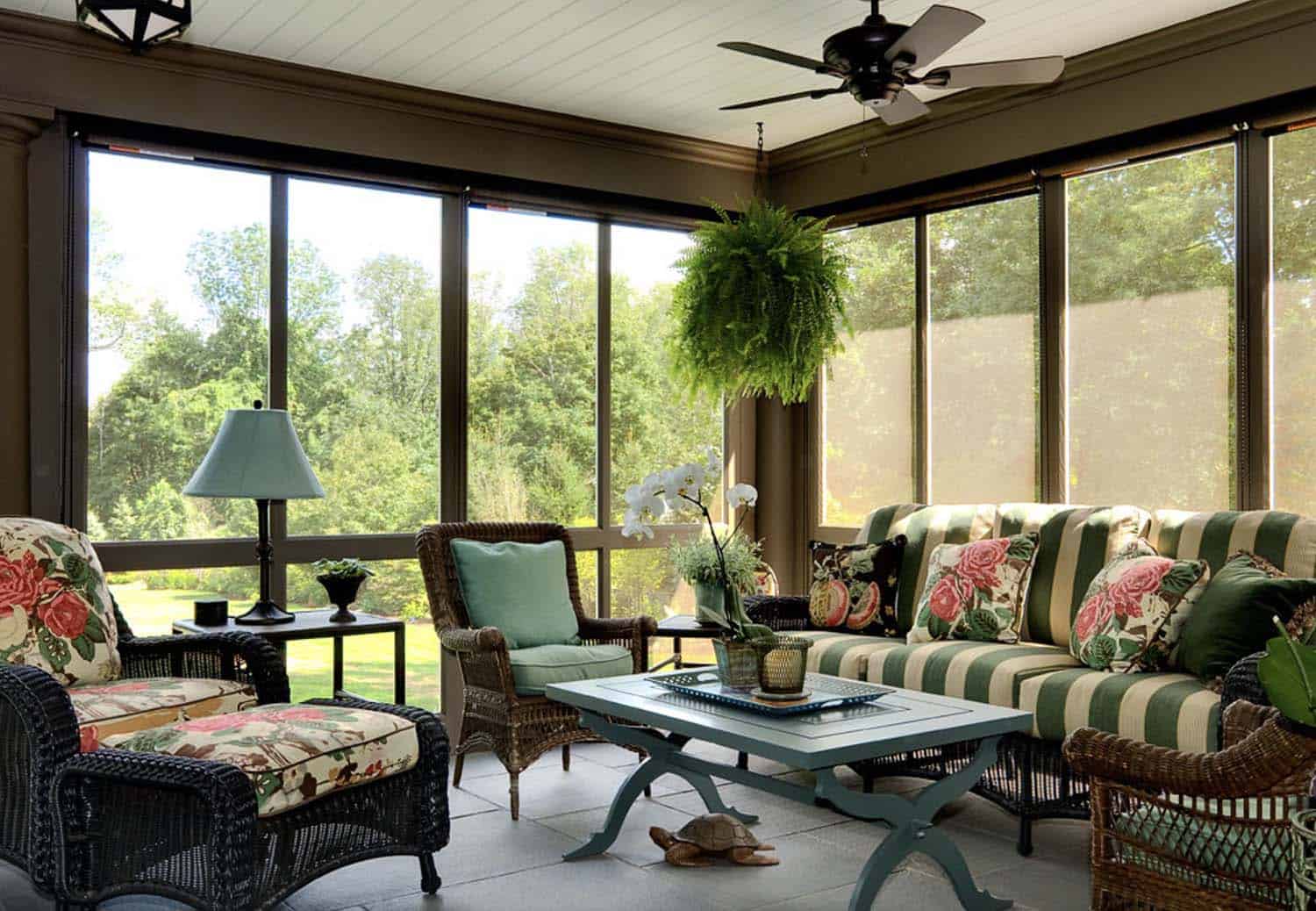 screened porch addition to a period home with wicker furniture and pops of color