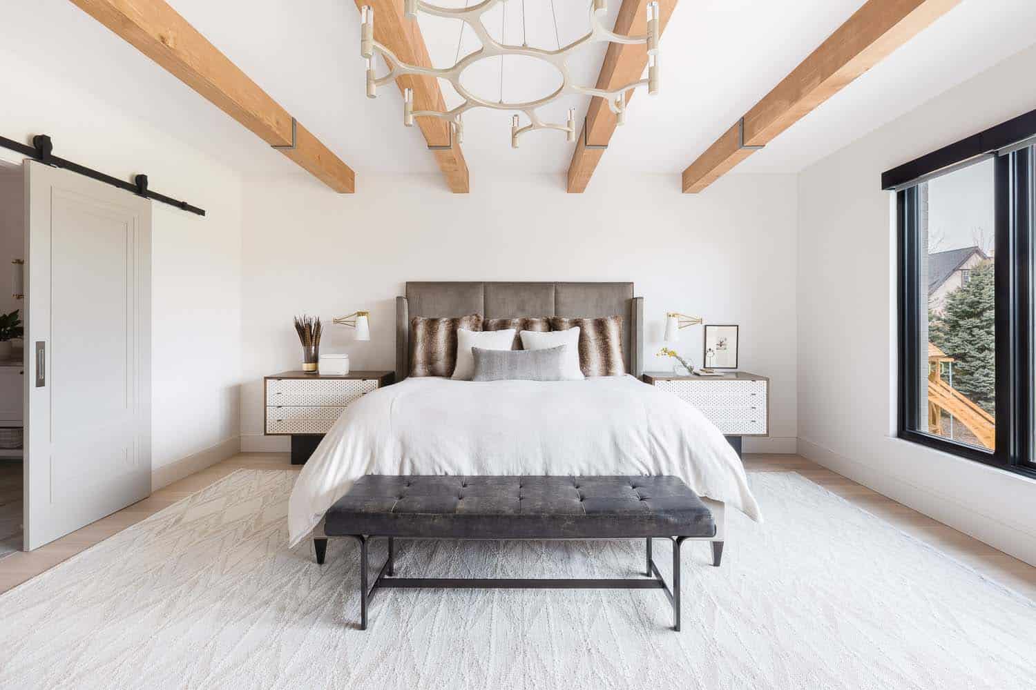 transitional style bedroom with wood beams on the ceiling