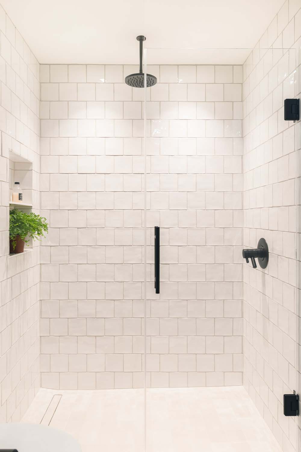 transitional style bathroom with a white tile shower
