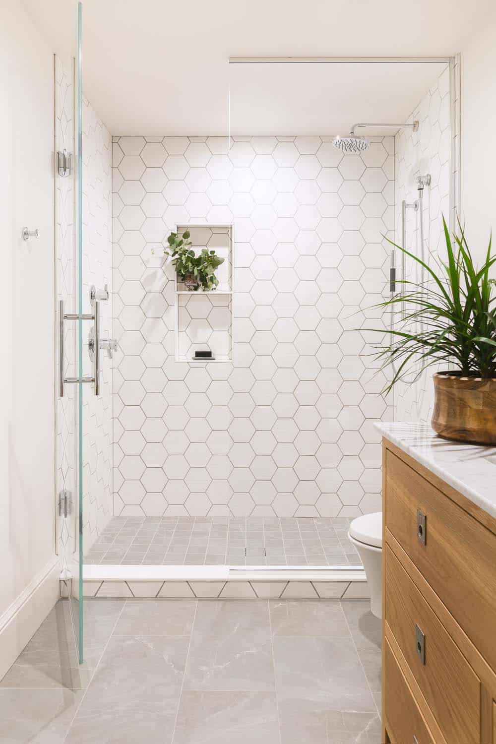 transitional style bathroom with a vanity and white tile shower