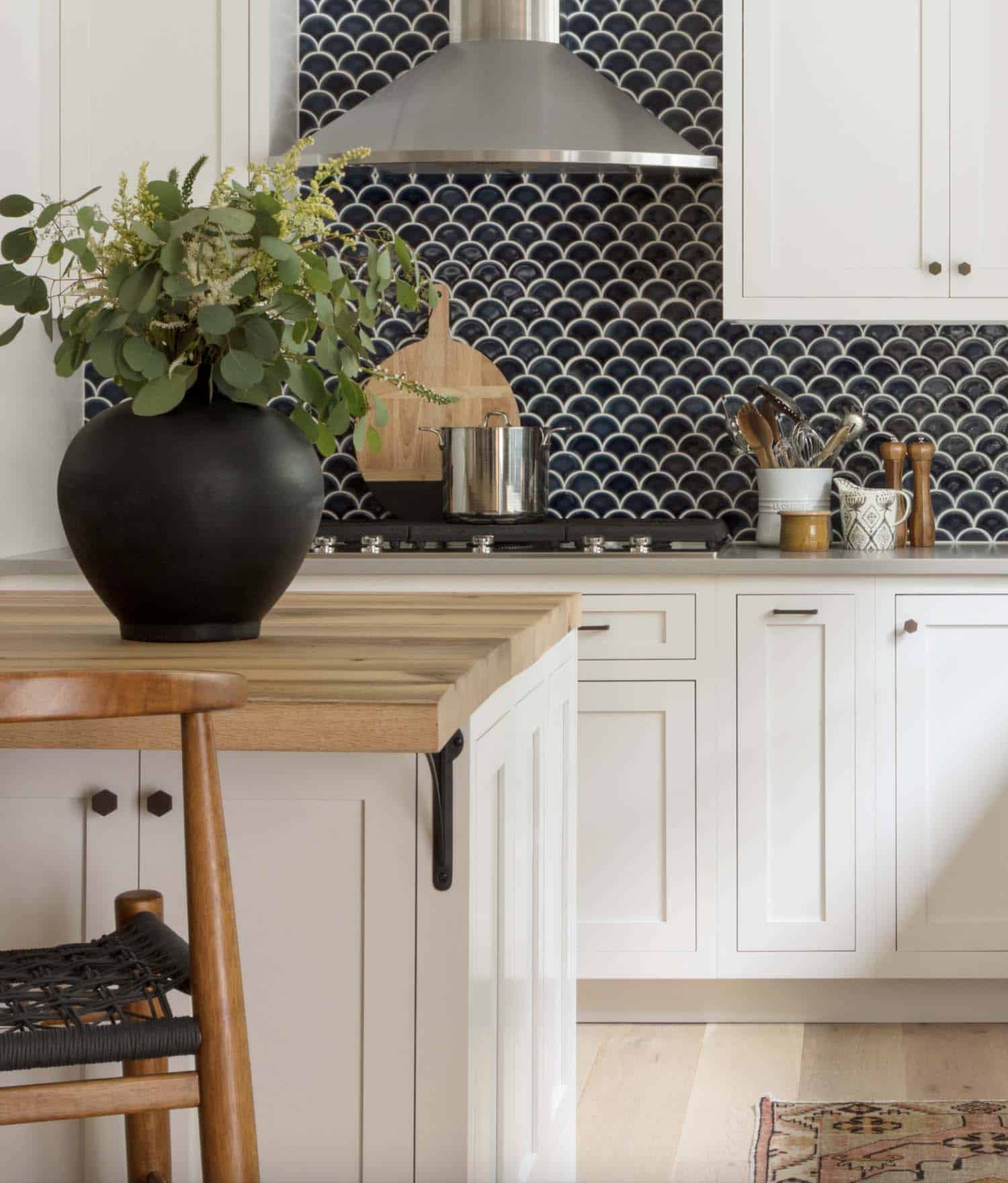 farmhouse kitchen with white cabinets and a blue backsplash tile