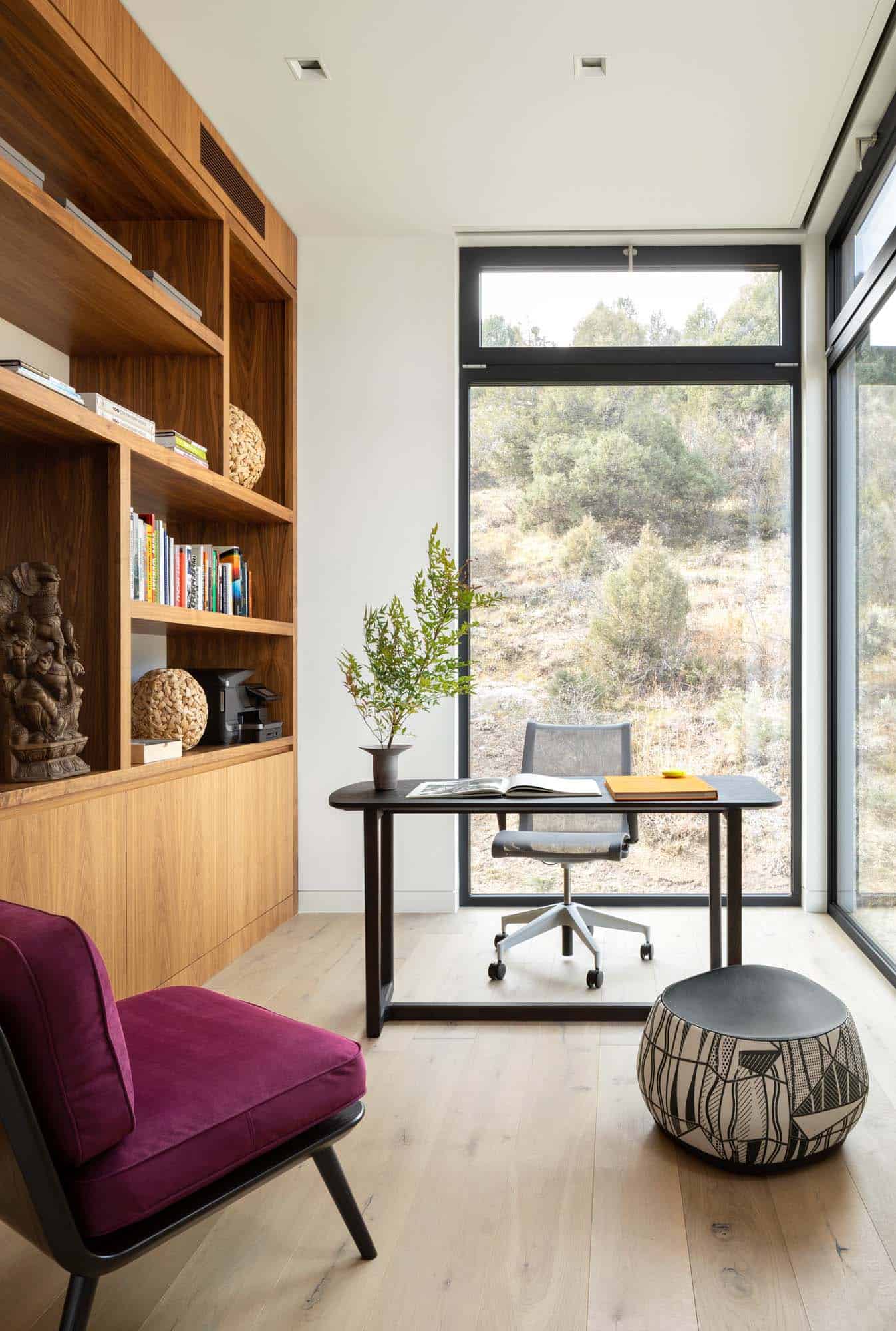 modern home office with built-ins and large windows
