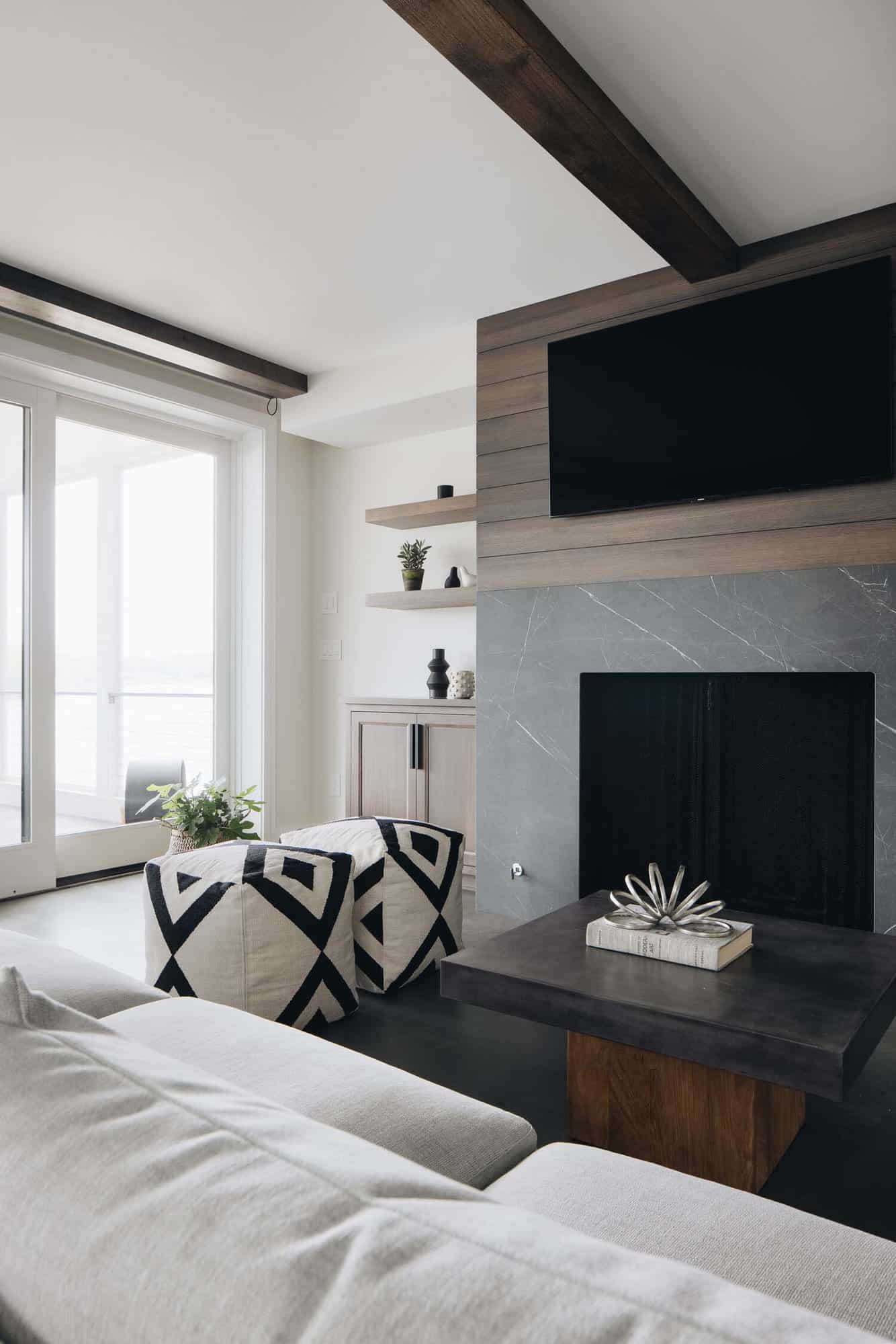 beach style family room with a fireplace and tv mounted above