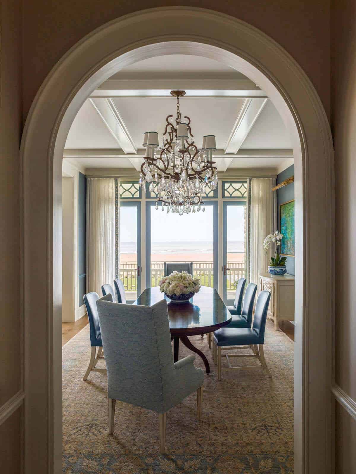 beach style dining room with an arched entryway