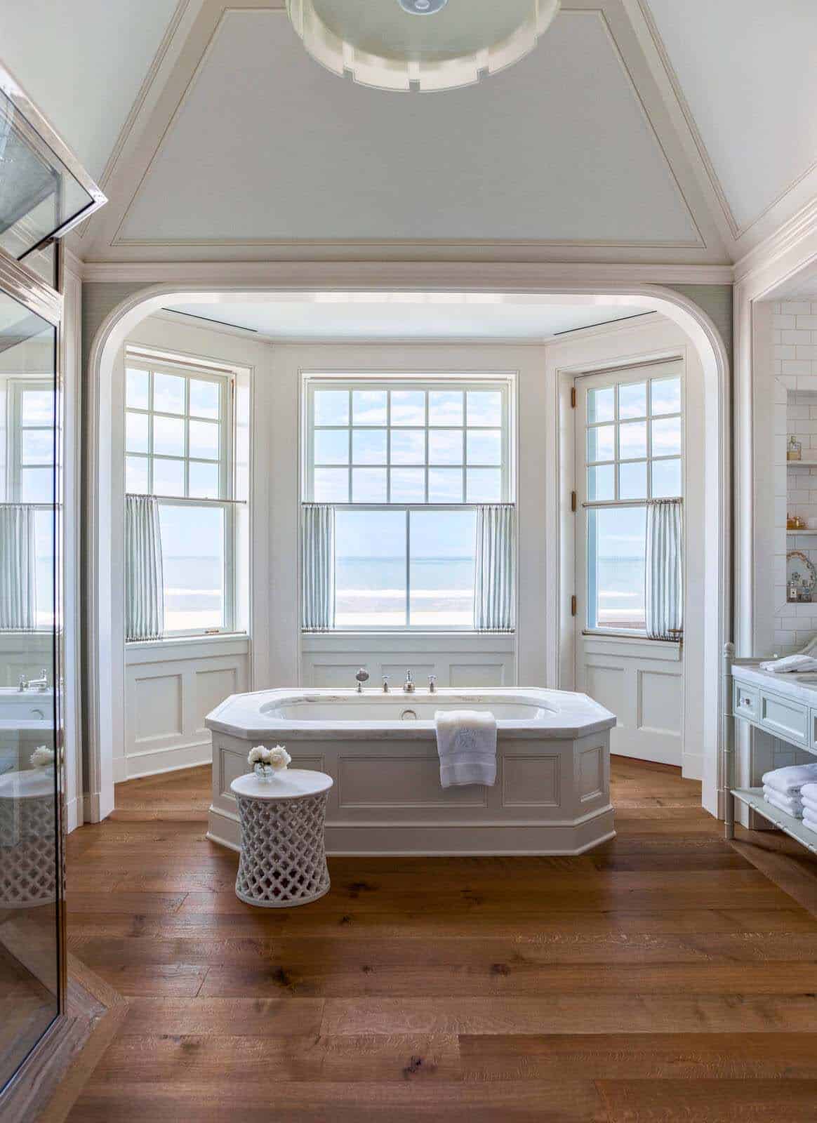 beach style bathroom with a soaking tub and windows