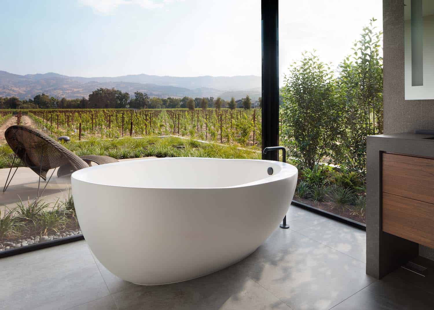 contemporary bathroom with a freestanding tub and large windows