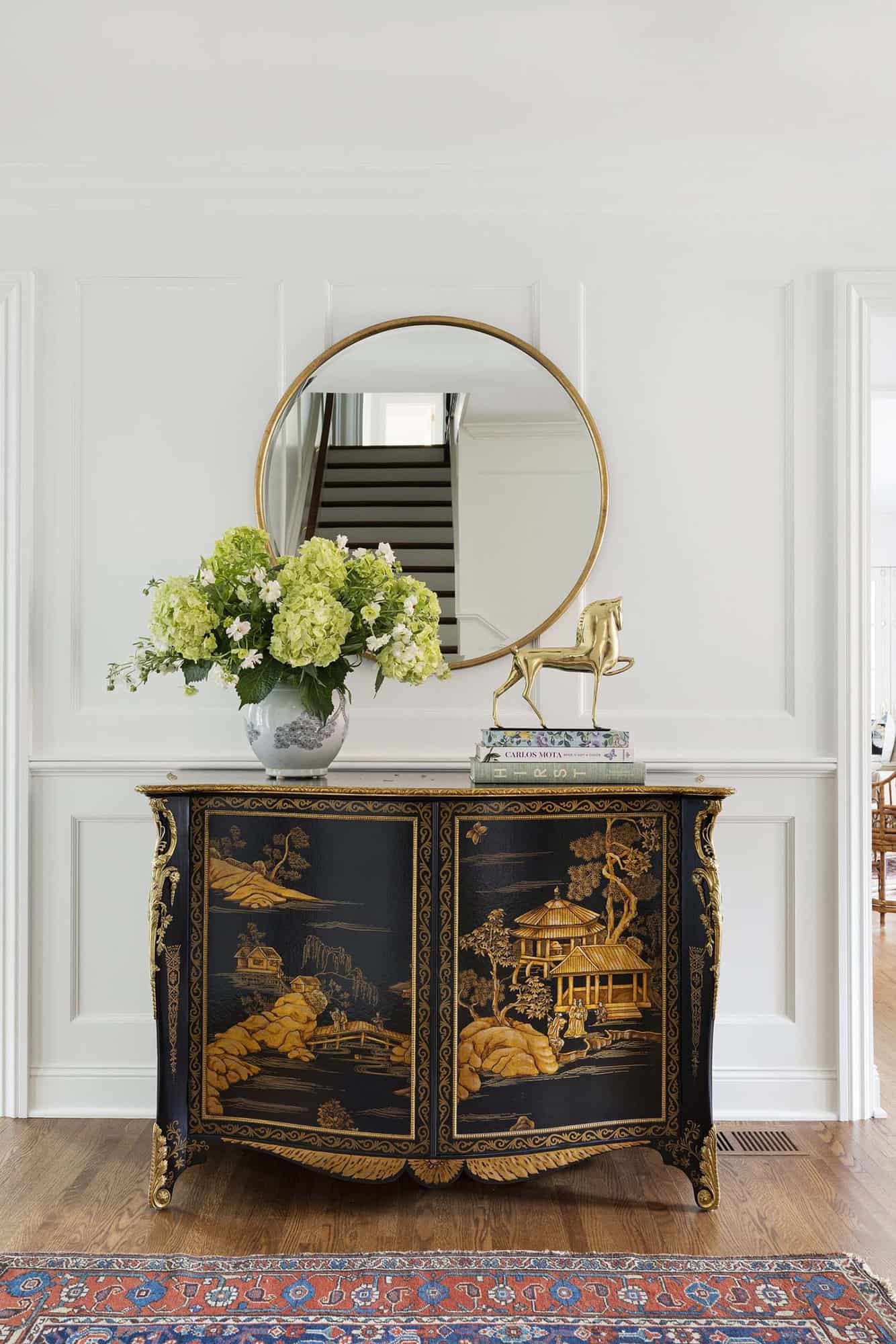 colonial home foyer with a chinoiserie cabinet