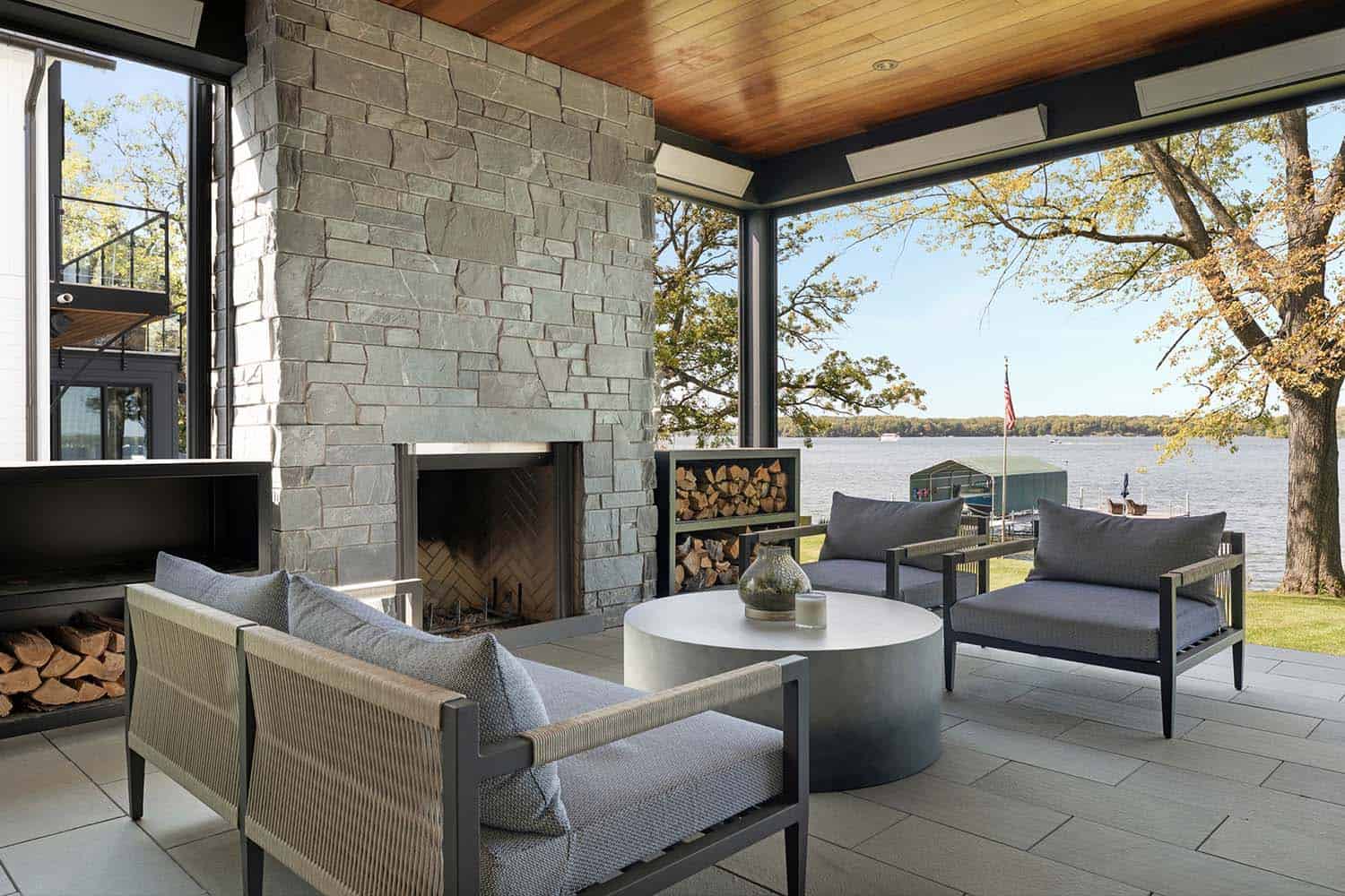 contemporary covered porch with a fireplace and lake views
