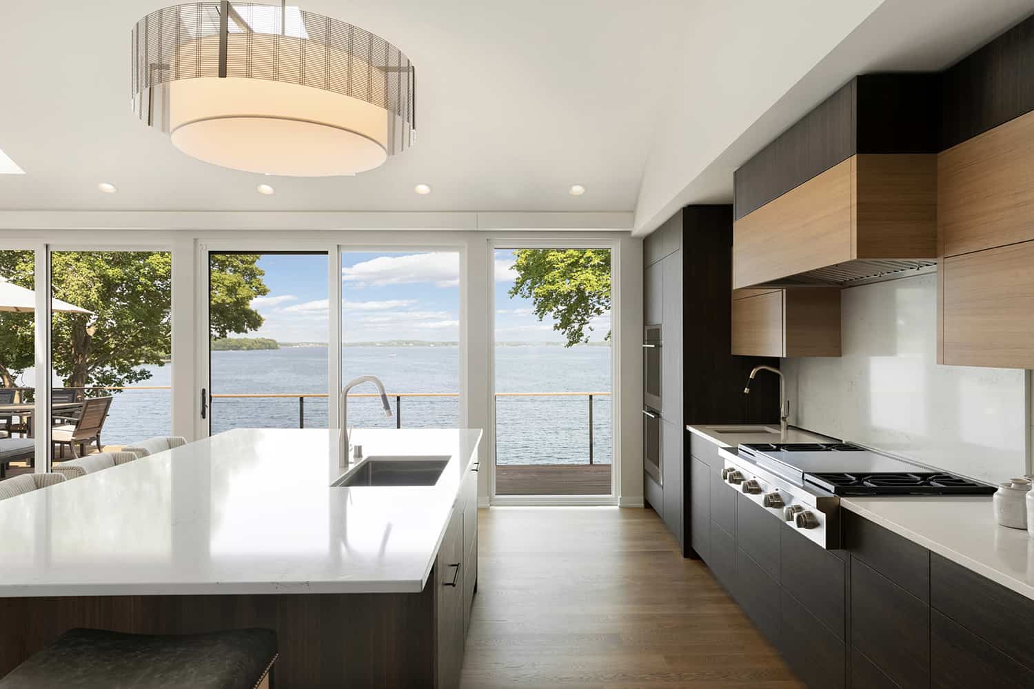 contemporary kitchen looking through large windows to the lake