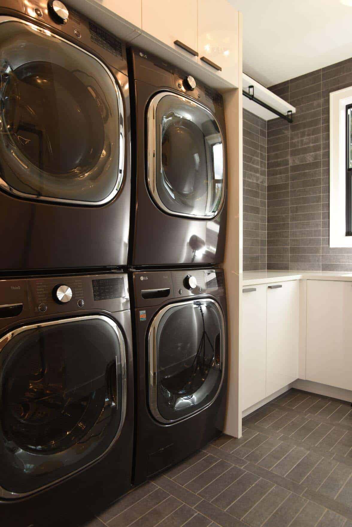 contemporary laundry room with two washers and two dryers stacked