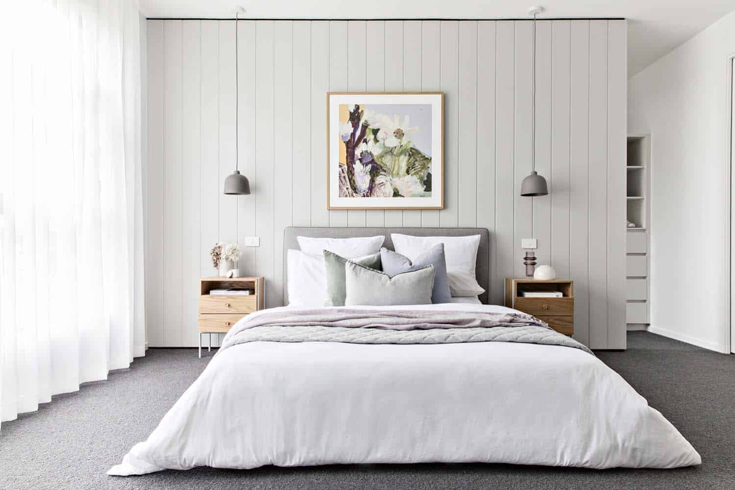 Scandinavian style bedroom with a wood panel wall and pendant lights