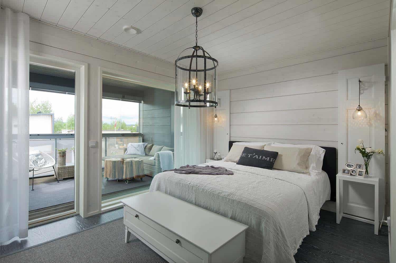 scandinavian bedroom with white furniture and a dark upholstered headboard