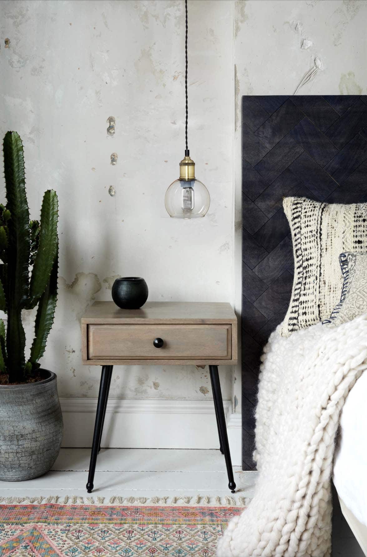 Scandinavian style bedroom with a bedside table and hanging light