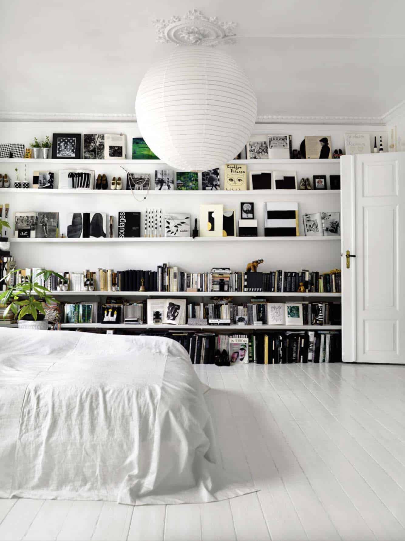 black and white bedroom color scheme with a wall of bookshelves