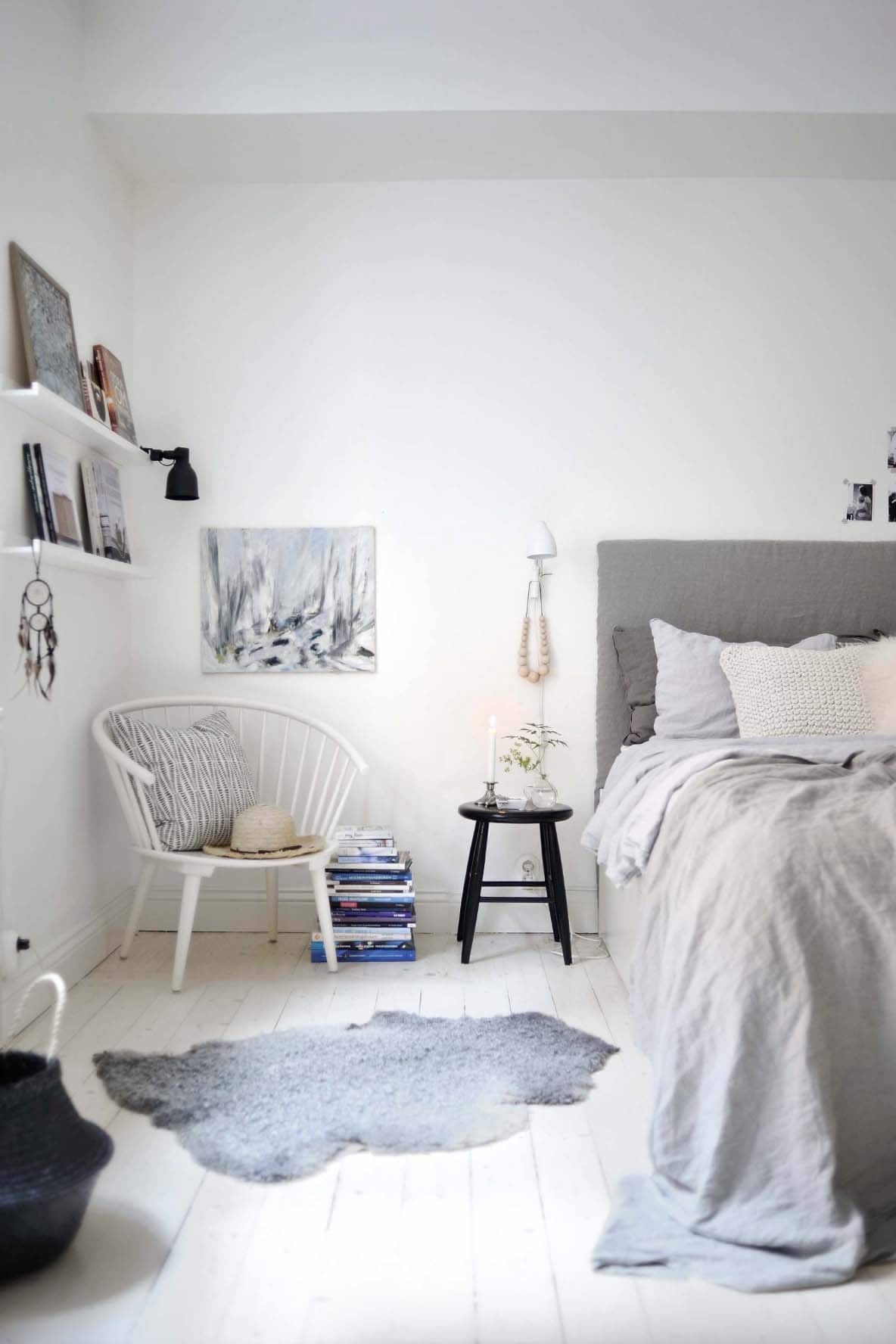 Scandinavian style bedroom with layers of bedding and wall shelves
