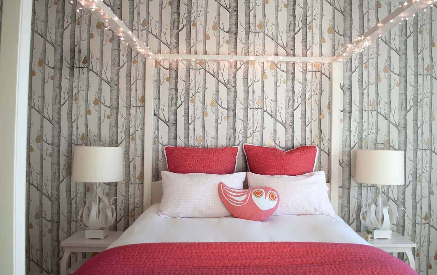 young girls bedroom with a canopy of fairy lights and trees wallpaper