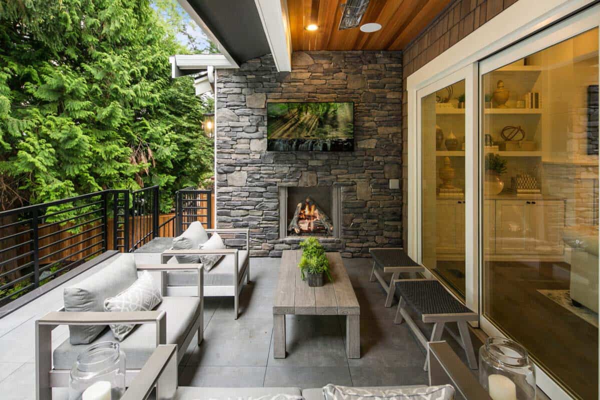 outdoor covered deck features grilling station, gas fireplace, outdoor tv and ceiling heaters