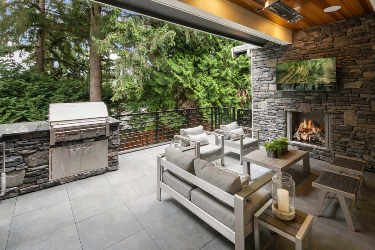 outdoor covered deck features a grilling station, gas fireplace, outdoor tv, and ceiling heaters