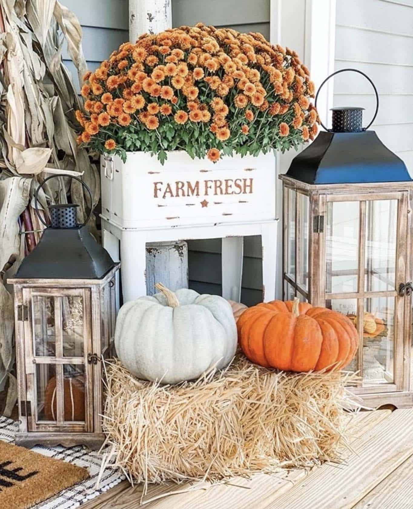 fall lanterns on the front porch with mums and pumpkins