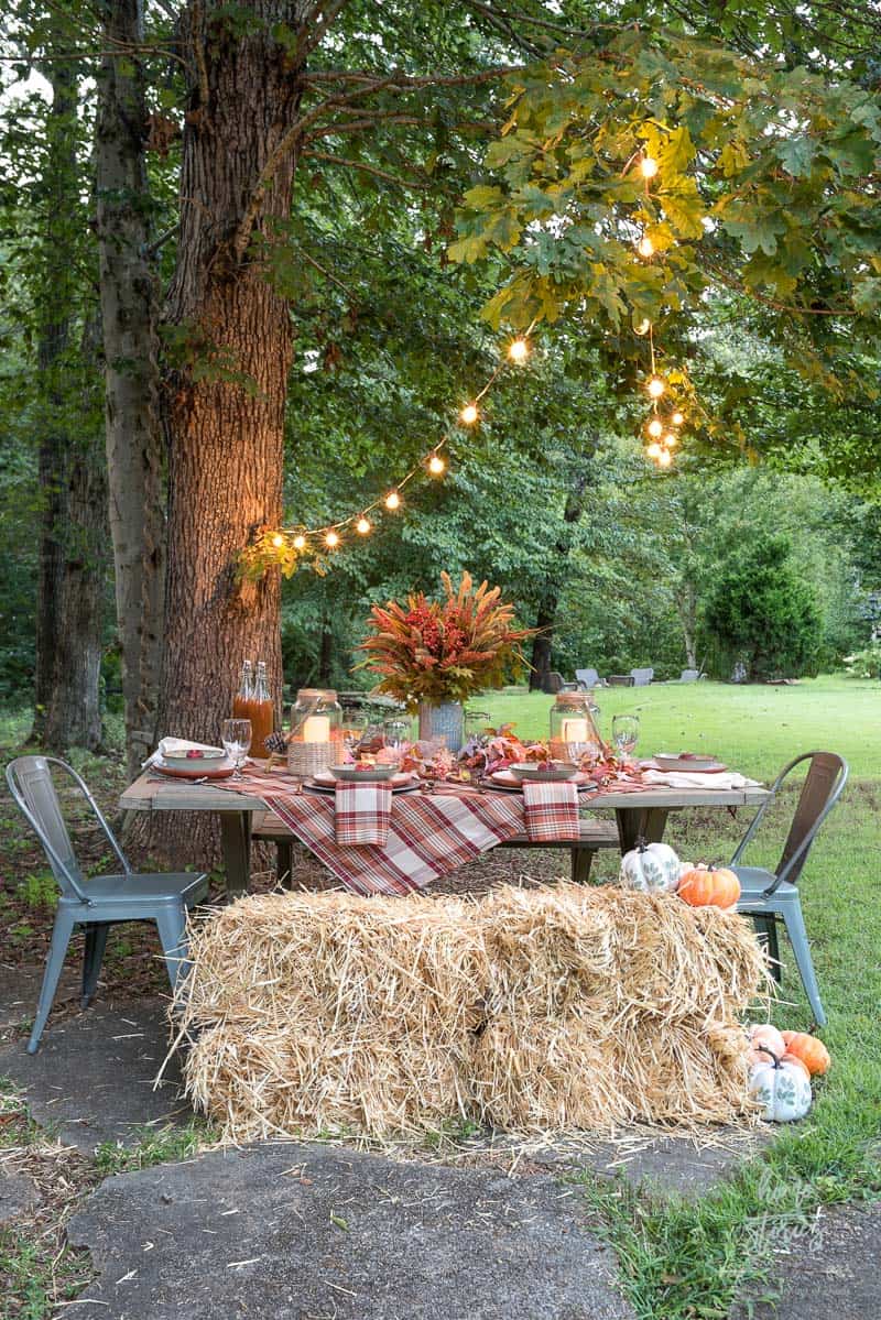 outdoor dining table with fall decor and hay bale seating