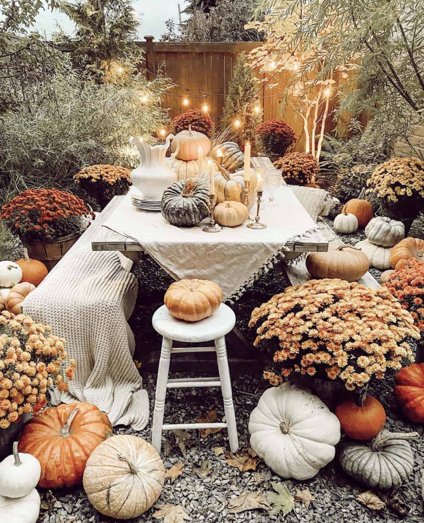 outdoor fall dining table with pumpkins and mums