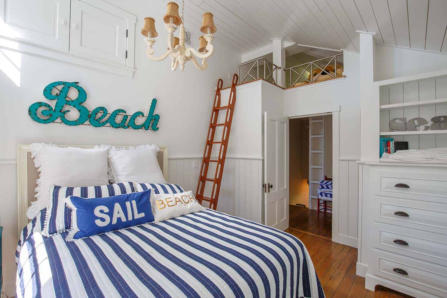 beach style bunk bedroom with a ladder and a loft