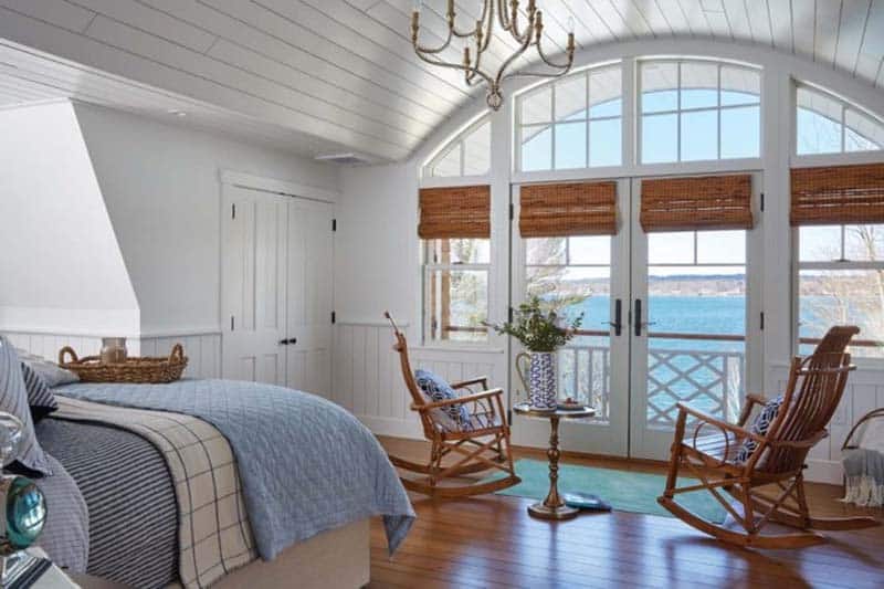 beach style bedroom with a large window overlooking the water