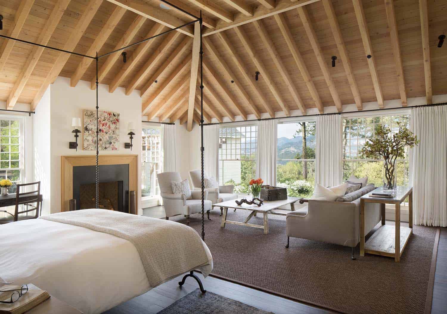 romantic farmhouse style bedroom with a wood ceiling and a fireplace